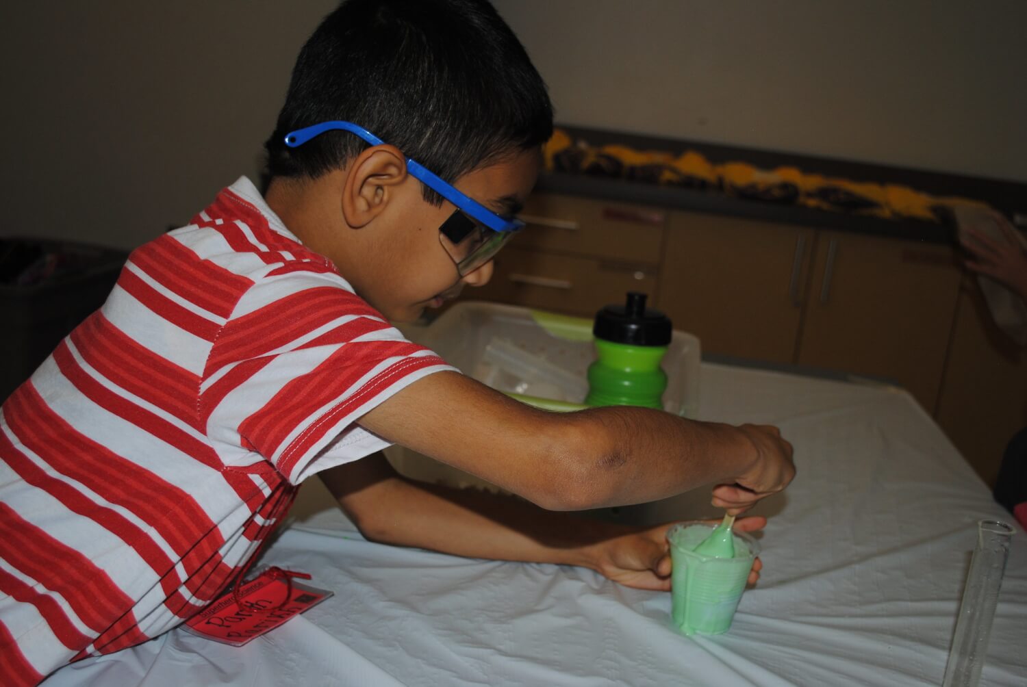 A boy makes green slime during camps