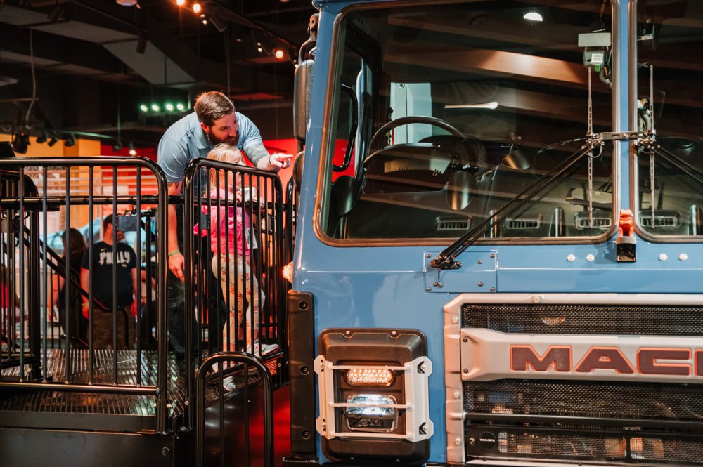 Photo of a parent and their child exploring the Mack truck installation