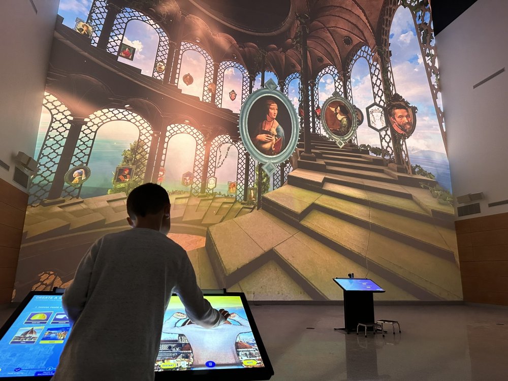 Photo of a child using one of the Leonardo Experience activity kiosks in Curiosity Hall