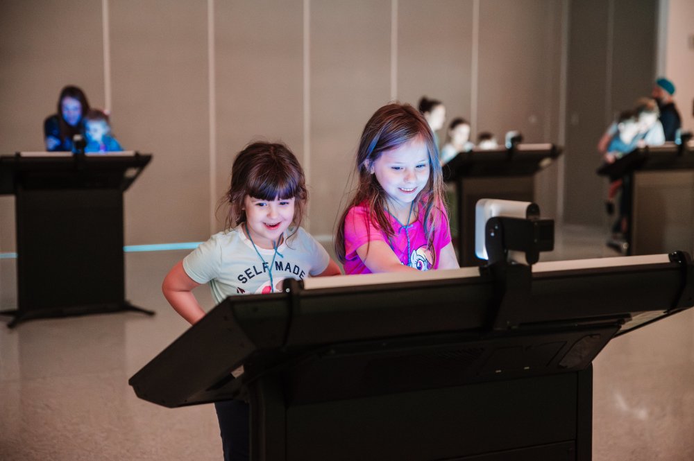 Photo of a children using one of the Leonardo Experience activity kiosks in Curiosity Hall